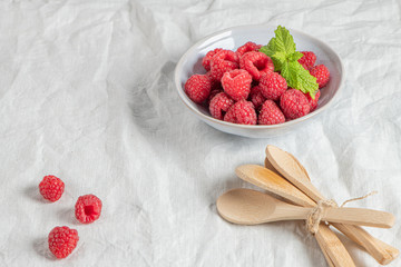 Bowl of delicious fresh ripe raspberries on table, closeup view