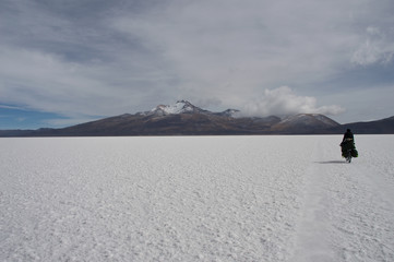 cycling traveler pedaling in the salt desert in Uyuni in Bolivia