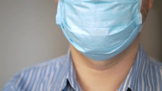 a sad man with virus, covid-19 and mask on his face for antivirus protection taking deep breath, rapid breathing