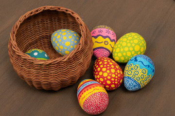 Basket with Easter eggs hand painted on a wooden table