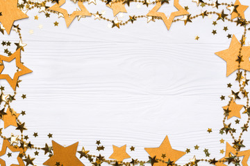 Flat lay frame of big and small stars of confetti. Golden beads of shine stars