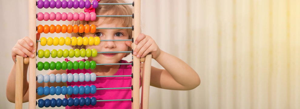 Little beautiful girl holding multi-colored abacus in her hands. Preschool girl with bright educational toys. education preschool baby hands are on the accounts