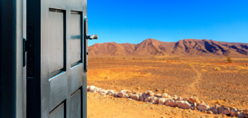 Opened door concept with a desert landscape in the background
