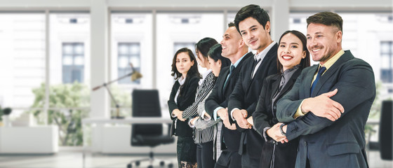 business background of diverse businesspeople asian and caucasian businesspeople standing and line up in row in board room and holding each others hands showing teamwork and cooperation