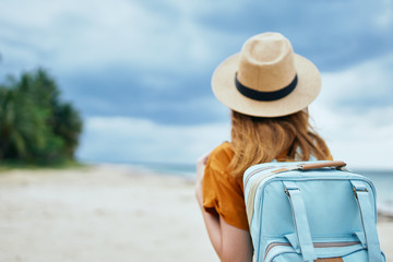 woman with suitcase on the beach