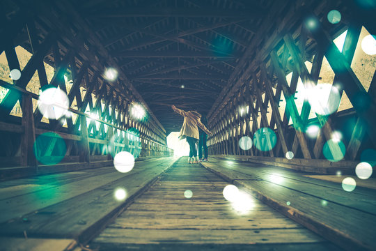 Rear View Of People Walking In Covered Bridge