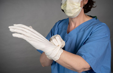 Nurse with scrubs on doning PPE