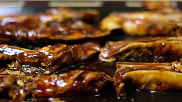 Close up footage of marinated lamb strips with soy and oyster sauce in an oven tray.