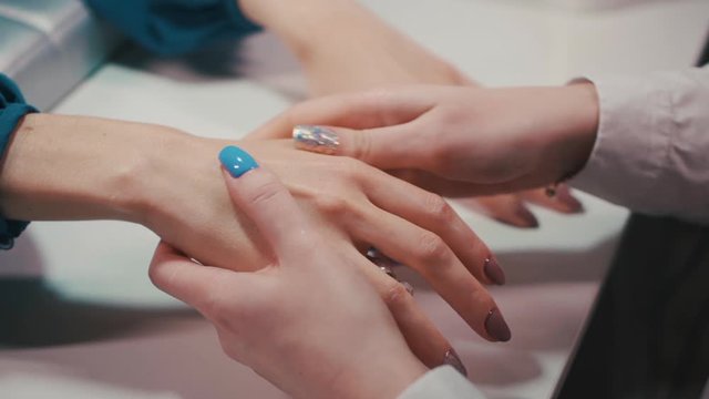 manicure artist making relaxing hand massage in spa salon