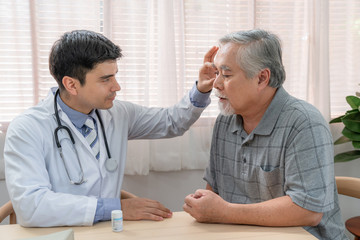Obraz premium Male ophthalmologist doctor examining elderly patient eye at home visit
