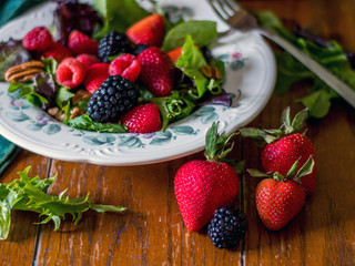 beautiful healthy fruit and green salad on a wooden table