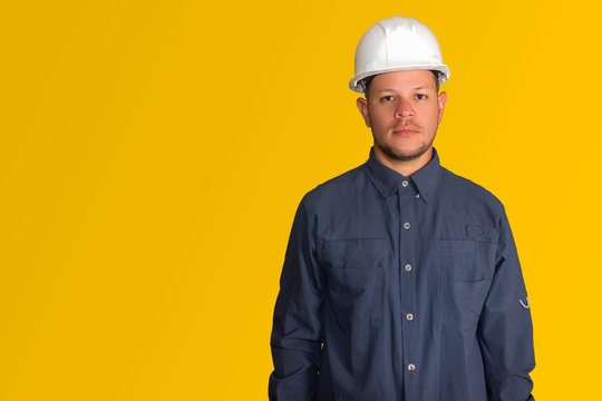 Hombre hispano con casco blanco en fondo amarillo