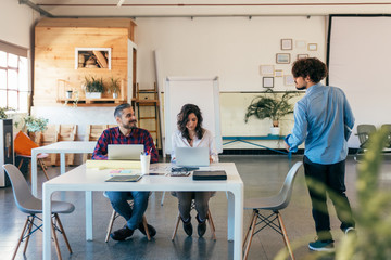 Startup team sharing ideas for project in meeting room. Business colleagues in casual sitting together in contemporary office space. Brainstorming concept