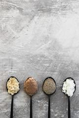 plant-based diet ingredients, spoons lined up on kitchen counter with sweet ingredients including coconut cocoa oats and chia seeds