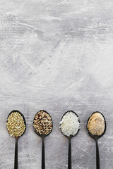 plant-based diet ingredients, spoons lined up on kitchen counter with mixed grains and carbs including buckwheat quinoa rice and breadcrumbs