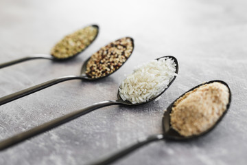 plant-based diet ingredients, spoons lined up on kitchen counter with mixed grains and carbs...
