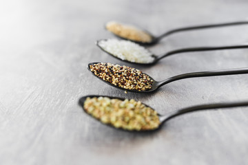 plant-based diet ingredients, spoons lined up on kitchen counter with mixed grains and carbs including buckwheat quinoa rice and breadcrumbs
