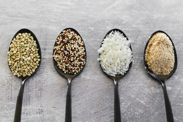plant-based diet ingredients, spoons lined up on kitchen counter with mixed grains and carbs...