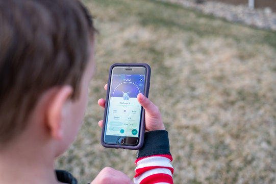 Tiffin, Iowa, USA: 4/2020:  Caucasian boy playing Pokemon Go, a popular mobile app game. 
