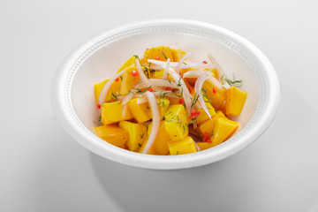 Vegetarian cebiche with mango cubes, onions and chili served on a styrofoam box