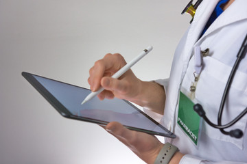 Healthcare worker using tablet to conduct healthcare. doctor or nurse practitioner Writing prescription. Physician assistant wearing stethoscope