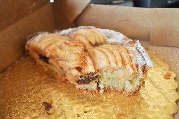 Apple pie cut in half in a golden take away box