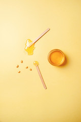 Depilatory wax of Golden color, depilatory spatulas, hot wax type, for face and body, Golden granules on a yellow background