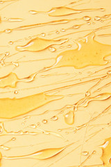 Background of melting honey on a yellow background, spreading honey place for text, fresh sweet honey flows