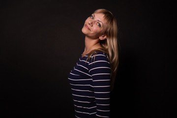 Fototapeta premium Young woman posing with happy smile. Isolated on black background