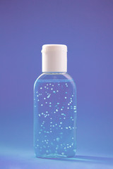 A bottle of hand sanitizer gel. Hand hygiene as coronavirus protection. Antivirus and antibacterial product. Blue liquid with white round granules