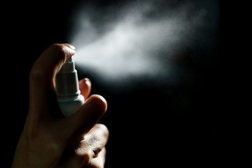 Hand using sanitizer spray, alcohol spraying disinfectant to stop spreading  coronavirus or COVID-19.