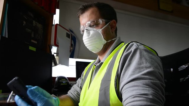 Man with medical face mask and gloves work at workplace