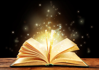 Magic light emanating from open old book on table