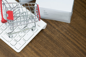 Top view  trolley on laptop keyboard.A cart and box product  .Electronic commerce that allows consumers to directly buy goods from a seller over the internet.Shopping online concept.