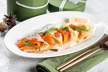 Stuffed pancakes with trout and red caviar