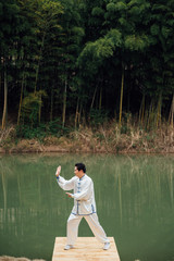 Asian aged man tai chi at the lake