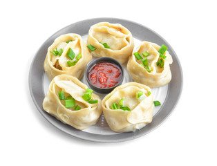 Plate with oriental dumplings and sauce on white background