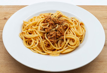 Traditional italian spaghetti with tuna with tomato sauce on wooden table