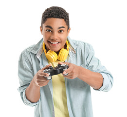 African-American teenage boy playing video game on white background © Pixel-Shot