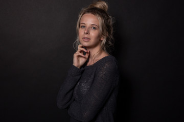 Young woman posing for photoshoot. Isolated on black background