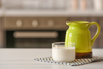 Glass and jug of milk on kitchen table
