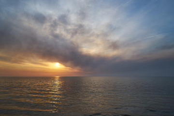 Sea sunset. Smoke wildfires sweeping across the sky.