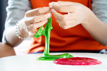 Obraz na płótnie Canvas Hand Holding Homemade Toy Called Slime, Kids having fun and being creative by science experiment