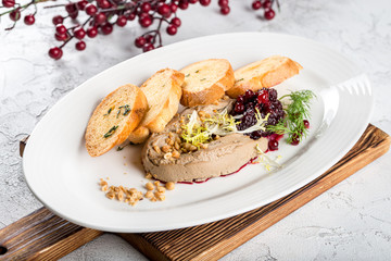 Pate served with bread, nuts, jam on a plate