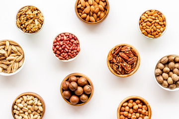Set of macadamia, hazelnut, walnut, almond, pistachio, pecans nuts on white background top-down pattern