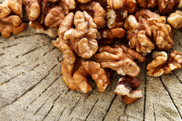 Walnuts on brown wooden background.