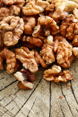 Walnuts on brown wooden background.