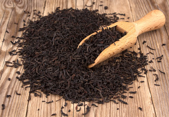 Dry tea leaves isolated on on a wooden table