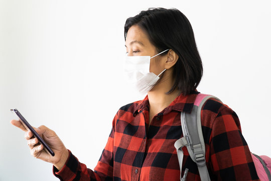 Traveller woman under surgical face mask covering mouth and nose. Awareness and Watch out Corona Virus or COVID-19 concept. - Powered by Adobe