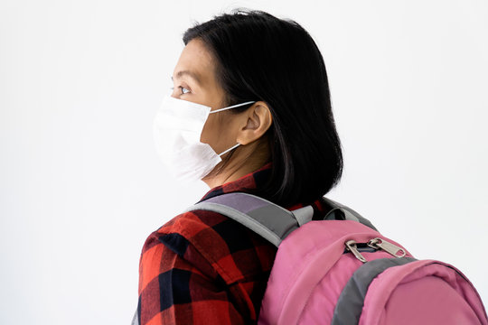 Traveller woman under surgical face mask covering mouth and nose. Awareness and Watch out Corona Virus or COVID-19 concept.